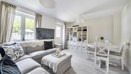 Living room with sofas, TV, storage unit, dining table and large window.