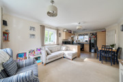 Open plan living area with sofas leading to dining space and kitchen.