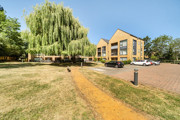 Apartment building with parking spaces, a lawn, and a footpath.