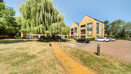 Apartment building with parking spaces, a lawn, and a footpath.