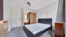 Bedroom with double bed, wardrobe, chest of drawers and mirror.