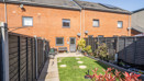 Rear garden with lawn, fencing and terraced houses in the background