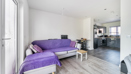 Open-plan living space with sofa, coffee table, dining table with chairs and kitchen area.