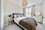Bedroom with double bed, bedside tables and large window.