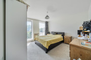 Bedroom with double bed, fitted furniture and a window.