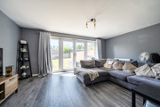 Bright living room with large sofa, french doors and natural lightf