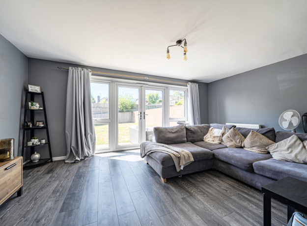 Bright living room with large sofa, french doors and natural lightf