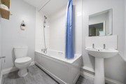Bathroom with a toilet, sink, bathtub and shower curtain.