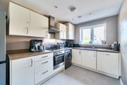 Contemporary kitchen with white cabinets, integrated oven and large window