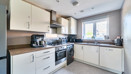 Contemporary kitchen with white cabinets, integrated oven and large window