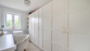 Third bedroom with white wardrobes, desk, chair, and window at the end.