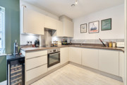 Kitchen with white cabinets, integrated oven and countertop appliances.
