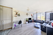 Bright open living area with wooden-effect flooring, wall décor and seating space