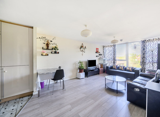 Bright open living area with wooden-effect flooring, wall décor and seating space