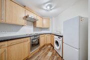 Kitchen with cabinets, oven, washing machine and fridge freezer.