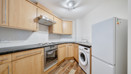 Kitchen with cabinets, oven, washing machine and fridge freezer.