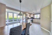 Open plan dining and kitchen area with neutral flooring and garden views