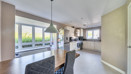 Open plan dining and kitchen area with neutral flooring and garden views