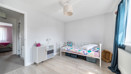 Children's bedroom with single bed, cupboard, and window with curtain.