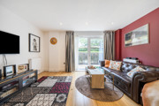 Living room with sofas, rug, television, and patio doors.