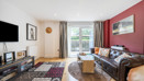 Living room with sofas, rug, television, and patio doors.