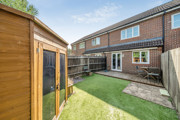 Rear garden with lawn, wooden shed, and fenced boundaries.