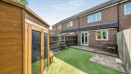 Rear garden with lawn, wooden shed, and fenced boundaries.