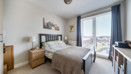 Bedroom with double bed, bedside tables, and window with curtains.