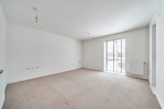 Living room with carpeted floor and floor-to-ceiling window.