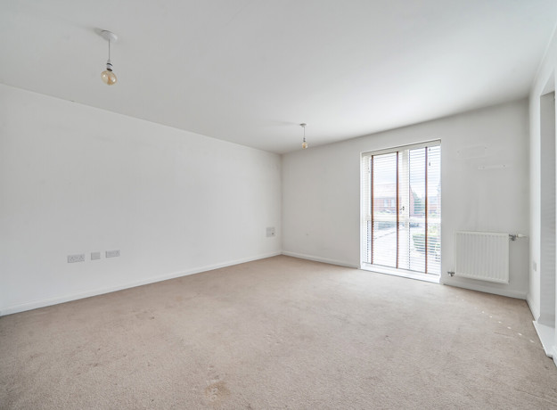 Living room with carpeted floor and floor-to-ceiling window.