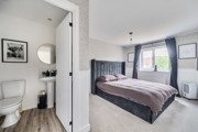 Bedroom with double bed, bedside tables, window with curtains and door into ensuite.