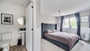 Bedroom with double bed, bedside tables, window with curtains and door into ensuite.