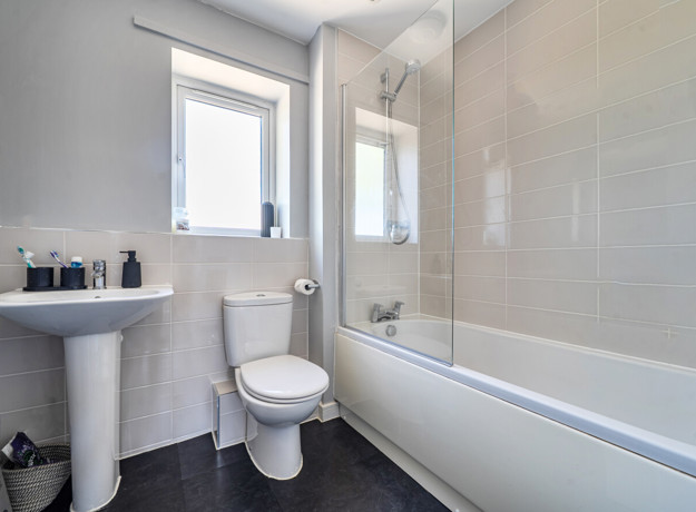 Modern bathroom with bathtub, wall tiles, toilet and sink