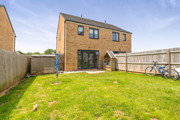Rear garden with lawn, fenced boundaries, and patio area.