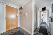 Entrance hallway with wooden door and patterned flooring.