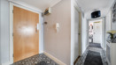 Entrance hallway with wooden door and patterned flooring.