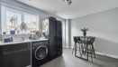 Kitchen view with counter, washing machine, and window with blinds.