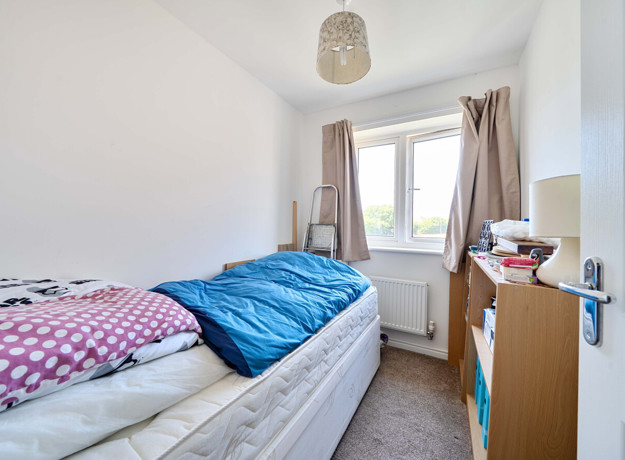 Bedroom with a single bed, desk and window.