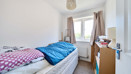 Bedroom with a single bed, desk and window.