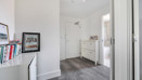 Hallway with shelving unit, shoe cabinet and doorway to another room.