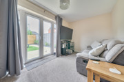 Living room with sofa, glass doors to garden and neutral decor.