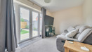 Living room with sofa, glass doors to garden and neutral decor.