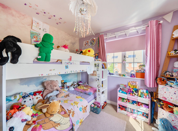 Children's bedroom with bunk bed, toys, shelving, pink walls and window.