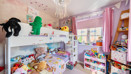 Children's bedroom with bunk bed, toys, shelving, pink walls and window.