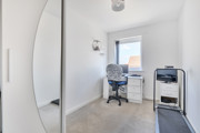 Home office with desk, chair, printer, and wardrobe.