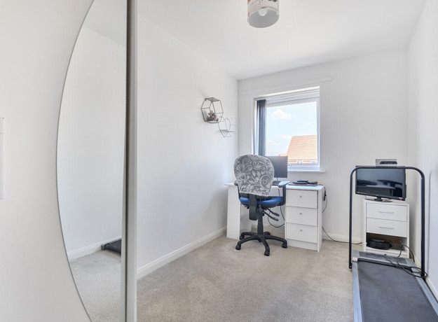 Home office with desk, chair, printer, and wardrobe.
