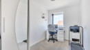Home office with desk, chair, printer, and wardrobe.