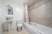 Bathroom with bathtub, shower, toilet, sink, and wall mirror.