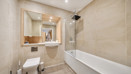 Bathroom with bathtub, shower, toilet, sink, and wall mirror.