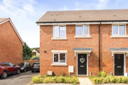 Red brick semi-detached house exterior with front door, windows, and small front garden.